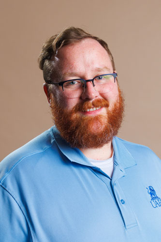 Jeffrey Tapp wearing a UAFS branded polo shirt and smiling