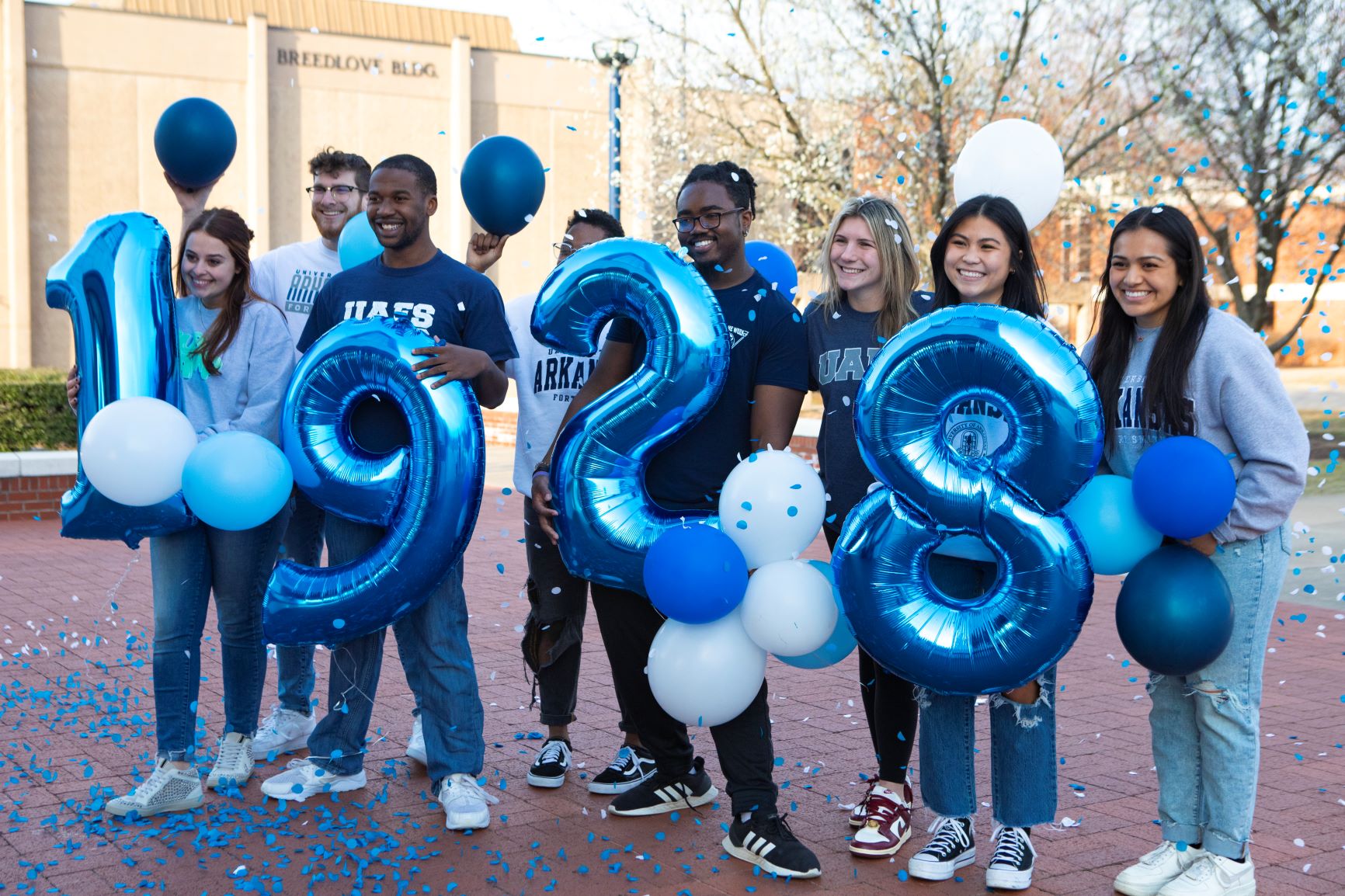 students hold 1928 balloons