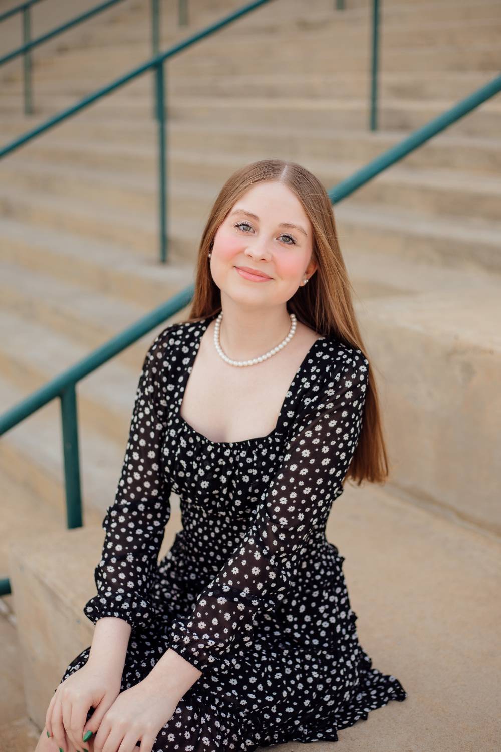 Faith Cureton sits on some stairs and smiles.