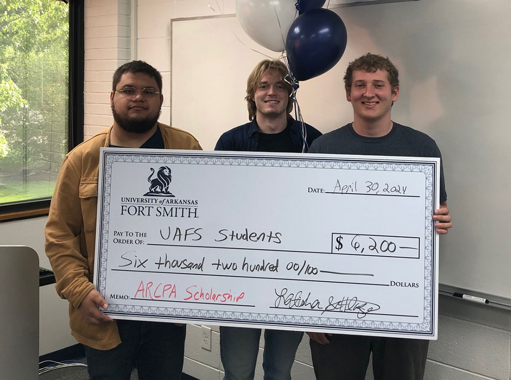 Connor Hadley-Kimbrell (left), Travis Johns, and Kevin Allen (right) stand with a large check for their ARCPA scholarships