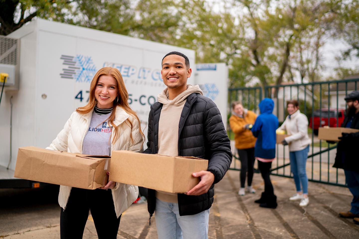 uafs supporters hold boxes of food during the fill the fridge giveaway