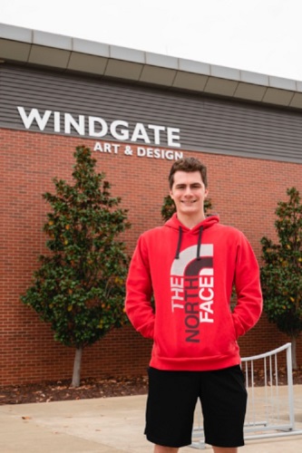 Aaron standing in front of the Windgate Building