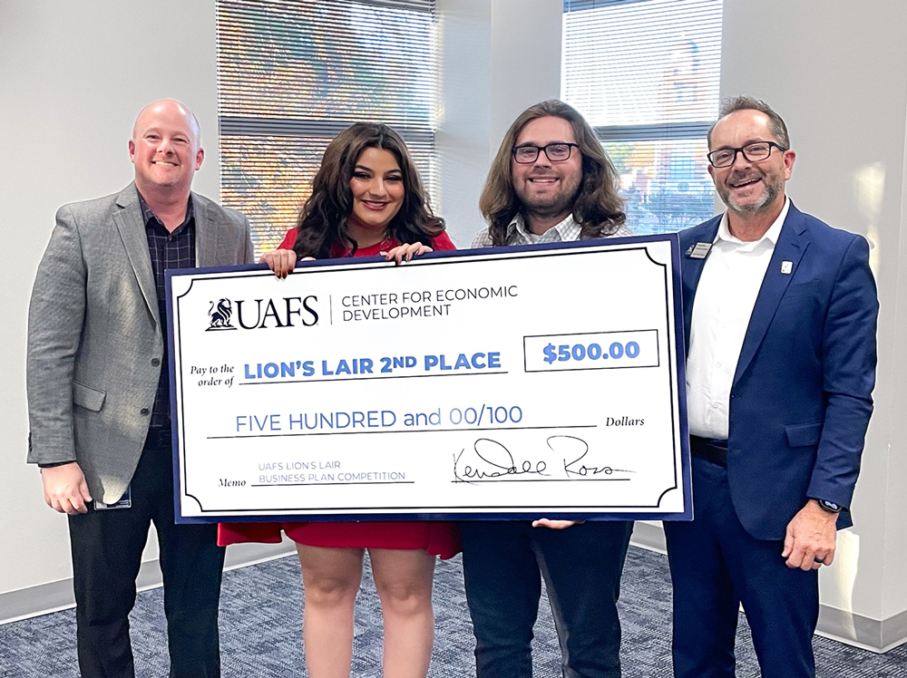 Reyna Lamb and Troy Rodriguez (center) accept their 2nd place prize presented by Justin Smith, director of the Jim Walcott Family Enterprise Center and Kendall Ross, associate vice chancellor of economic and workforce development.