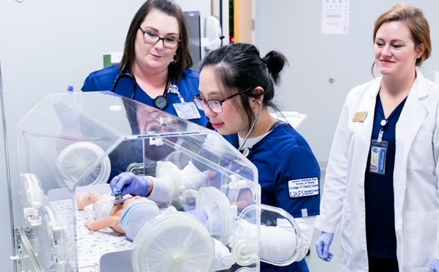 Nursing students and instructor at simulated incubator