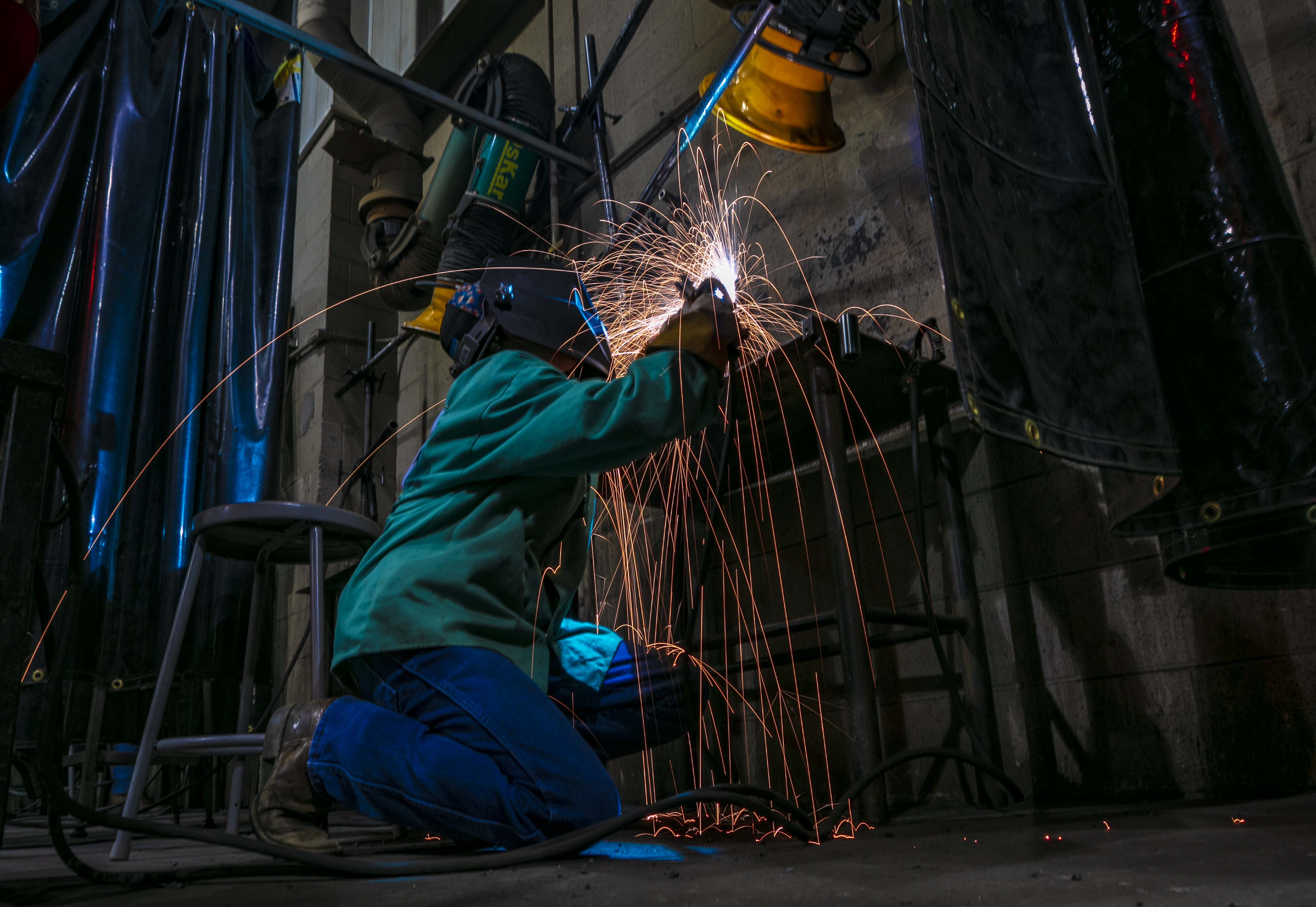 a welder with sparks around his metalwork